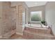 A luxurious bathroom featuring a soaking tub and separate tiled shower at 15829 W Bonitos Dr, Goodyear, AZ 85395