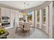 Sunlit dining area featuring a round table, chandelier, and large windows with views of the backyard at 15829 W Bonitos Dr, Goodyear, AZ 85395