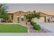 Inviting home featuring lush green lawn, desert landscaping, and a spacious driveway leading to the garage at 15829 W Bonitos Dr, Goodyear, AZ 85395