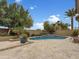 Resort style backyard featuring a sparkling pool, water feature, lush landscaping, and covered patio at 15829 W Bonitos Dr, Goodyear, AZ 85395