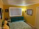 Bright bedroom features cheerful yellow walls, a futon, and a decorative patterned bedspread at 17429 E La Pasada Dr, Fountain Hills, AZ 85268