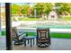 View of the backyard from the covered patio with outdoor seating and a view of the pool, stone fireplace, and landscaping at 1918 W Medinah Ct, Anthem, AZ 85086