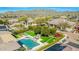 Aerial shot of a backyard featuring a pool, hot tub, patio with a fire pit and well-maintained green areas at 1918 W Medinah Ct, Anthem, AZ 85086