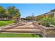 A serene backyard with an in-ground pool, spa, lounge chairs, manicured lawn, and lush landscaping create an ideal outdoor retreat at 1918 W Medinah Ct, Anthem, AZ 85086