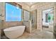 A luxurious bathroom with a freestanding tub, glass shower, and modern fixtures at 1918 W Medinah Ct, Anthem, AZ 85086