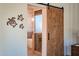 Rustic sliding barn door leading to the ensuite bathroom at 1918 W Medinah Ct, Anthem, AZ 85086