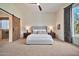 Spacious bedroom with a king bed, and rustic sliding barn door to the bathroom at 1918 W Medinah Ct, Anthem, AZ 85086