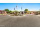 Welcoming community entrance with circular driveway and lush landscaping, displaying three flags at 1918 W Medinah Ct, Anthem, AZ 85086