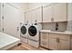 Well-organized laundry room with modern washer and dryer, ample cabinetry, and designer backsplash at 1918 W Medinah Ct, Anthem, AZ 85086