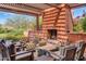 Inviting covered outdoor living space featuring a fireplace and comfortable lounge seating at 1918 W Medinah Ct, Anthem, AZ 85086