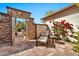 Cozy outdoor patio featuring stone accents, lounge chair, and vibrant red bougainvillea at 1918 W Medinah Ct, Anthem, AZ 85086