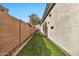 Narrow side yard with artificial grass, brick walls, and a small tree on a sunny day at 1918 W Medinah Ct, Anthem, AZ 85086