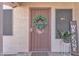 Inviting entryway with a secure screen door, a welcoming wreath, and pleasant potted plants on a tile floor at 2019 E Wahalla Ln, Phoenix, AZ 85024