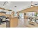 Modern kitchen with white cabinets, stainless steel appliances, and an open layout to a cozy living area at 2019 E Wahalla Ln, Phoenix, AZ 85024