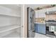 Pantry and stainless steel refrigerator next to the kitchen featuring blue lower cabinets and white upper cabinets at 2019 E Wahalla Ln, Phoenix, AZ 85024