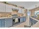 Well-lit kitchen features white and blue cabinets, stainless steel appliances, and neutral countertops at 2019 E Wahalla Ln, Phoenix, AZ 85024