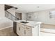 Stylish kitchen island with a sink, white cabinets, and adjacent staircase at 21208 N 58Th St, Phoenix, AZ 85054