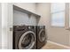 Modern laundry room with shelving, tile floors, and natural light at 21208 N 58Th St, Phoenix, AZ 85054