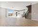 Open-concept living space with white kitchen, stainless appliances, and adjacent staircase at 21208 N 58Th St, Phoenix, AZ 85054