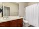 Bright bathroom featuring a wooden vanity cabinet and shower behind a white shower curtain at 2300 W Sunrise Pl, Chandler, AZ 85248