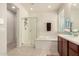 Modern bath featuring a glass shower, soaking tub, tile floors, and cherry cabinetry at 2300 W Sunrise Pl, Chandler, AZ 85248