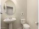 Powder room features a pedestal sink, round mirror, toilet, and light gray walls at 2300 W Sunrise Pl, Chandler, AZ 85248