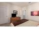 Cozy bedroom features neutral walls, carpet floors, and a dresser with a television at 2300 W Sunrise Pl, Chandler, AZ 85248