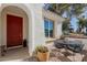 Inviting outdoor patio with a dining set, brick flooring, a bright red door, and lush greenery at 2300 W Sunrise Pl, Chandler, AZ 85248