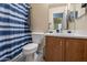 Well-lit bathroom with a blue and white shower curtain, wood-look floors, and single sink at 233 N 21St St, Coolidge, AZ 85128