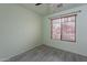 Bright bedroom features wood-look floors, a large window with blinds, and soft green walls at 233 N 21St St, Coolidge, AZ 85128