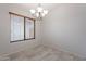 A simple, tiled room illuminated by a charming chandelier and a window at 233 N 21St St, Coolidge, AZ 85128