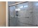 Updated shower with grab bars, glass door, shower head, and soap dish for accessibility at 233 N 21St St, Coolidge, AZ 85128