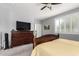 Bright bedroom featuring a wooden dresser, ceiling fan, and shuttered window at 24027 N 164Th Dr, Surprise, AZ 85387