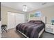 Bright bedroom with a large window and a bed with a dark comforter, bedside tables and a sliding-door closet at 2709 E Clarendon Ave, Phoenix, AZ 85016