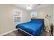 Modest bedroom with two sunlit windows and a bed with a blue comforter at 2709 E Clarendon Ave, Phoenix, AZ 85016