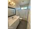 Bright bathroom featuring a shower-over-tub combo, modern vanity, and sleek gray wood-look flooring at 27411 N 256Th Dr, Wittmann, AZ 85361