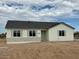 Single story home with neutral colors and desert landscaping under a cloudy sky at 27411 N 256Th Dr, Wittmann, AZ 85361