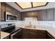 Close-up of kitchen featuring stainless appliances, Quartz countertops and dark cabinets at 2959 N 68Th Pl # 112, Scottsdale, AZ 85251