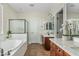 Bright bathroom featuring a soaking tub, glass-enclosed shower, white countertops, and dark wood cabinets at 3006 E Agritopia N Loop, Gilbert, AZ 85296