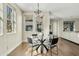 Bright dining area with modern chandelier, hardwood floors, and a glass table at 3006 E Agritopia N Loop, Gilbert, AZ 85296