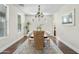 Classic dining room with hardwood floors, neutral paint, and a large area rug under the table at 3006 E Agritopia N Loop, Gilbert, AZ 85296