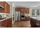 Well-equipped kitchen showcasing dark wood cabinetry, stainless steel appliances and a large island with white countertops at 3006 E Agritopia N Loop, Gilbert, AZ 85296