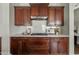 Close up of kitchen with custom cabinets, white countertop, tiled backsplash, and stainless steel hood at 3006 E Agritopia N Loop, Gilbert, AZ 85296