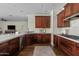 A kitchen featuring dark wood cabinets, stainless steel appliances, and a large island with white countertops at 3006 E Agritopia N Loop, Gilbert, AZ 85296