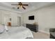 A main bedroom featuring neutral paint, a ceiling fan, dresser, and a door to an ensuite bathroom at 3006 E Agritopia N Loop, Gilbert, AZ 85296