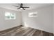 Bright bedroom featuring wood floors, a modern ceiling fan, and natural light from two windows at 3322 E Willetta St, Phoenix, AZ 85008