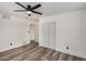 Bedroom with neutral walls, wood-look flooring, a ceiling fan, closet, and interior door at 3322 E Willetta St, Phoenix, AZ 85008