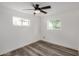 Bedroom with neutral walls, wood-look flooring, a ceiling fan, and natural light from two windows at 3322 E Willetta St, Phoenix, AZ 85008