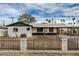 Charming single-story home featuring a black wrought iron fence, white paint, and a covered carport at 3322 E Willetta St, Phoenix, AZ 85008