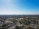 Expansive aerial view showcasing a neighborhood with tree-lined streets and homes with a skyline backdrop in the distance at 3511 E Elm St, Phoenix, AZ 85018